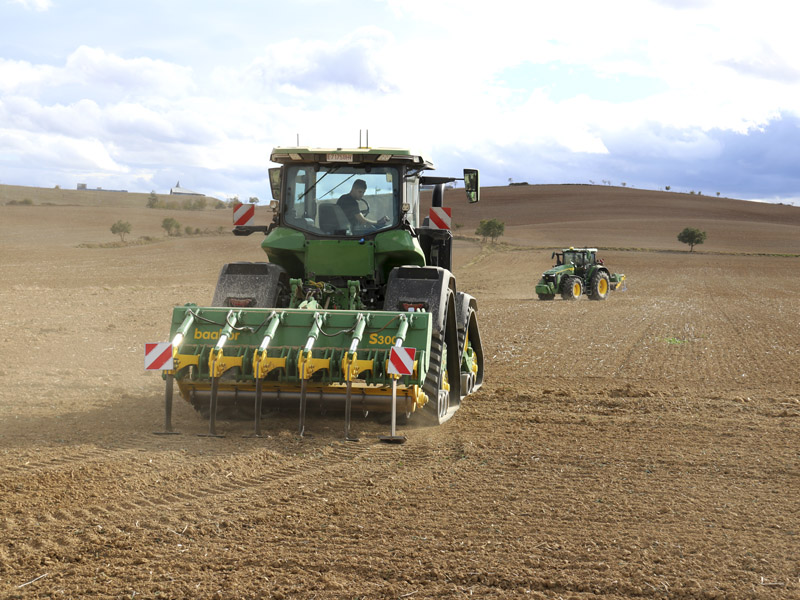 En primer plano subsolador baabor modelo S300 trabajando con un tractor John Deere 8RX, al fondo otro tractor John Deere más pequeño con otro subsolador.